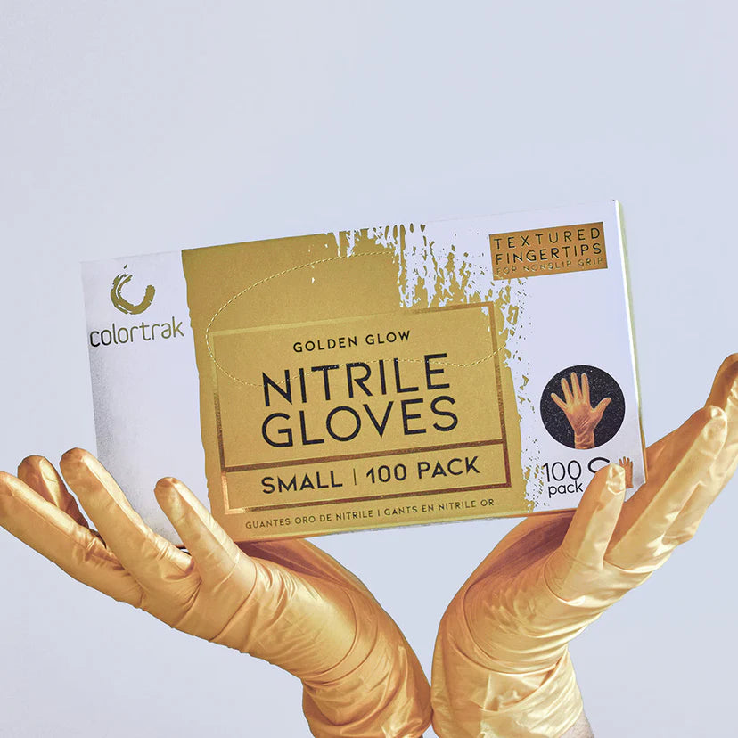 Colortrak Golden Glow nitrile gloves 100-count box held by gloved hands